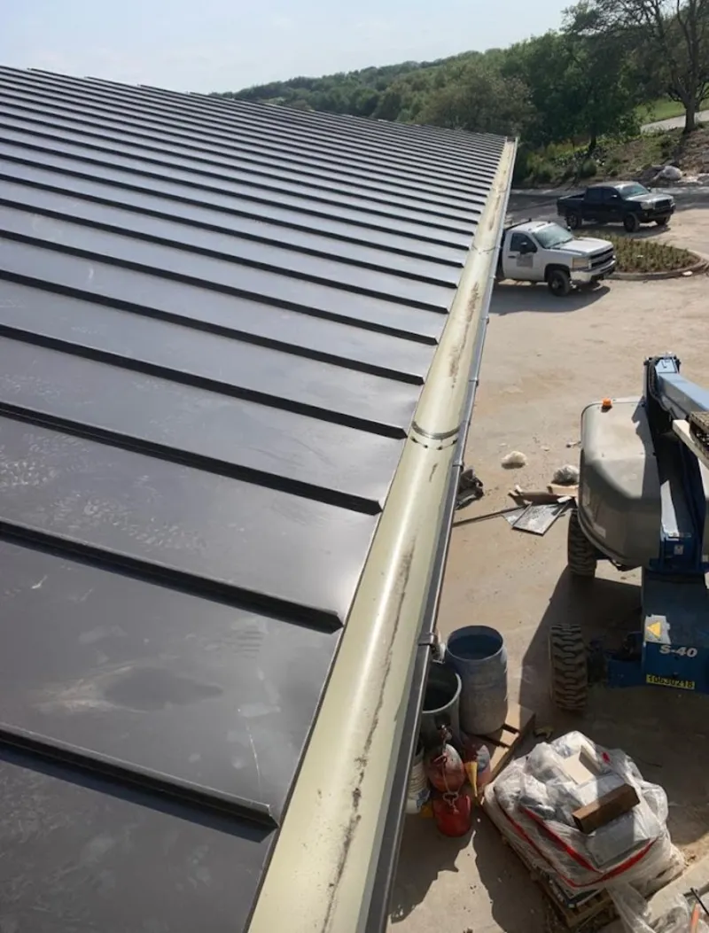 Standing seam panel and gutter detail on a metal roofing jobsite in Waterford